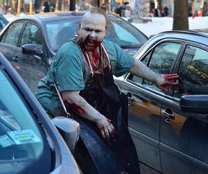 Fat vampire on the street in daylight between cars
