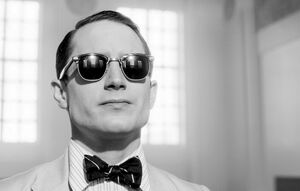 Elijah Wood sports some fancy glasses as John M. Brinnin in 