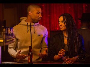 Adonnis Creed and his girlfriend sharing a drink at the club