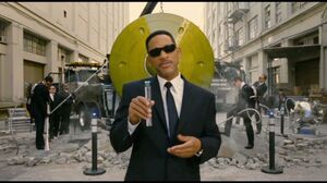 Agent K flashes some people and tells them to turn their cellphone off on the plane. Men in Black 3